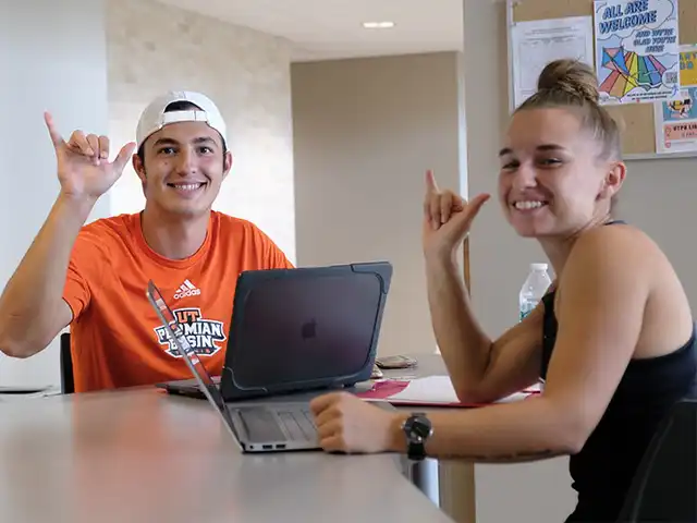 two students working on laptops 