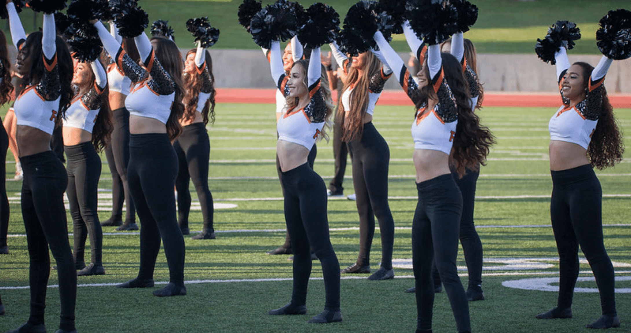 Dance team on football field with pom poms