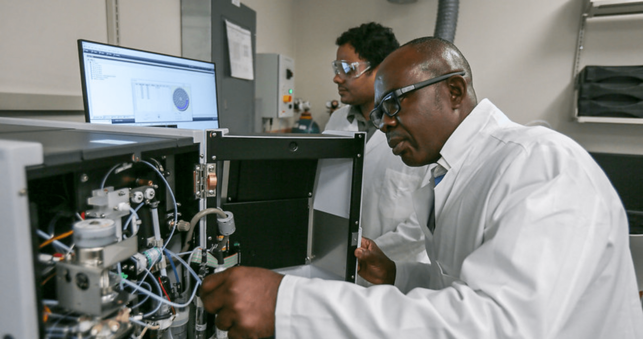 Two engineering professors in lab looking at machine