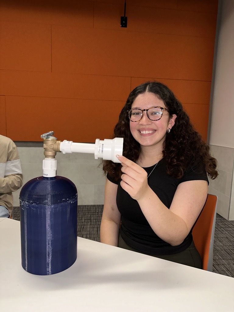 Verenice Campos displaying the tank to capture emissions