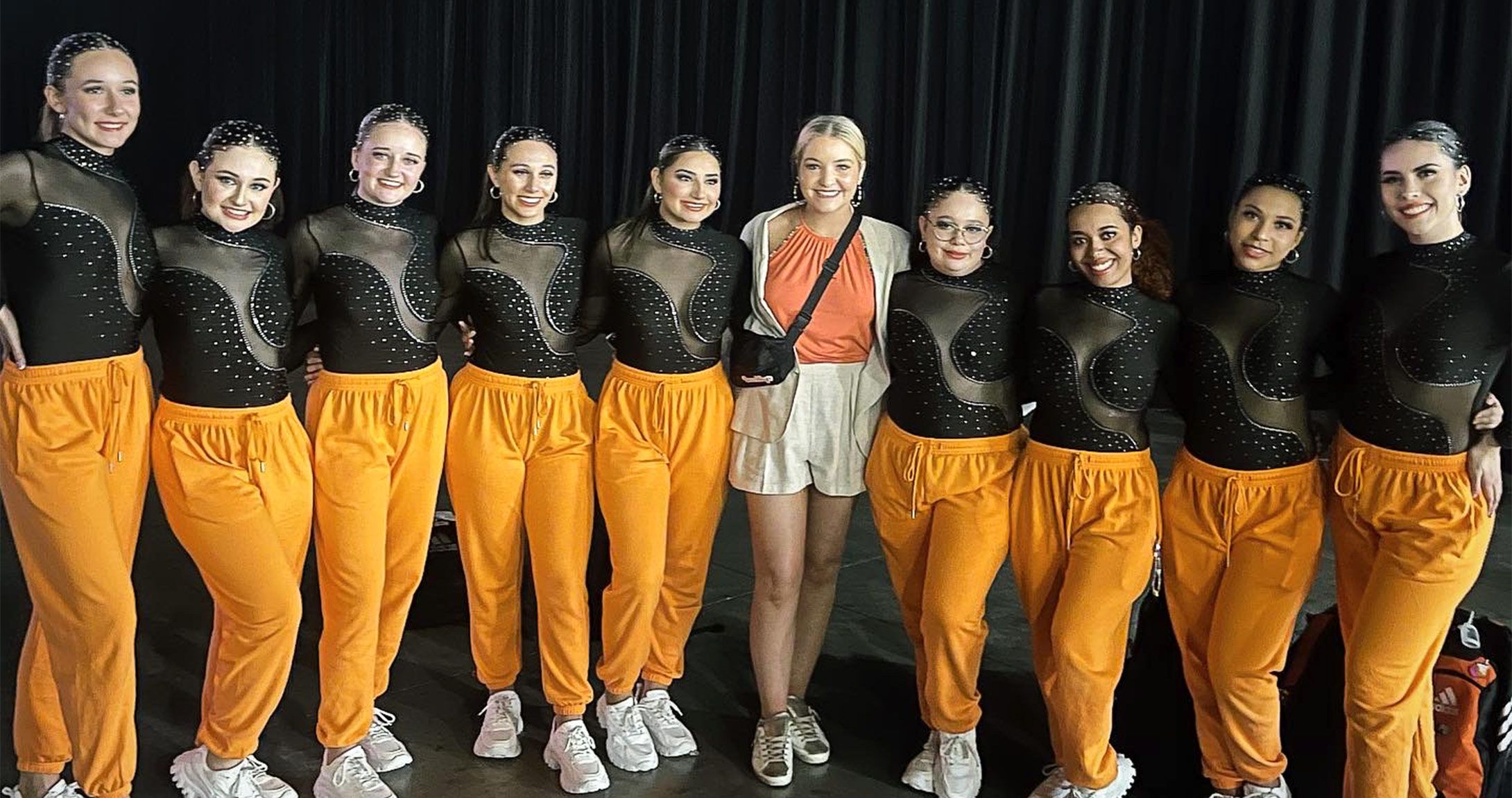Dance team smiling with new coach 