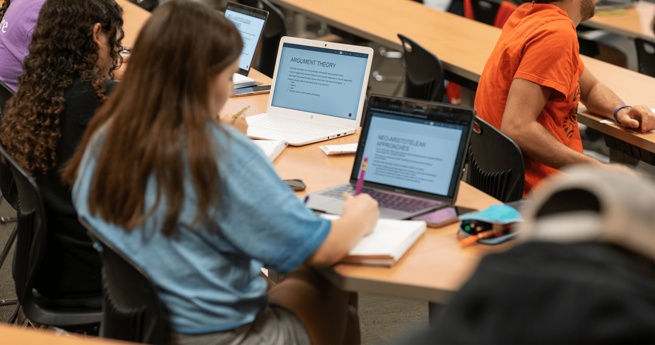 students in class with their laptops open