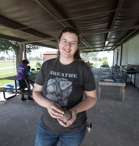 Danielle Collins smiling holding clay pot